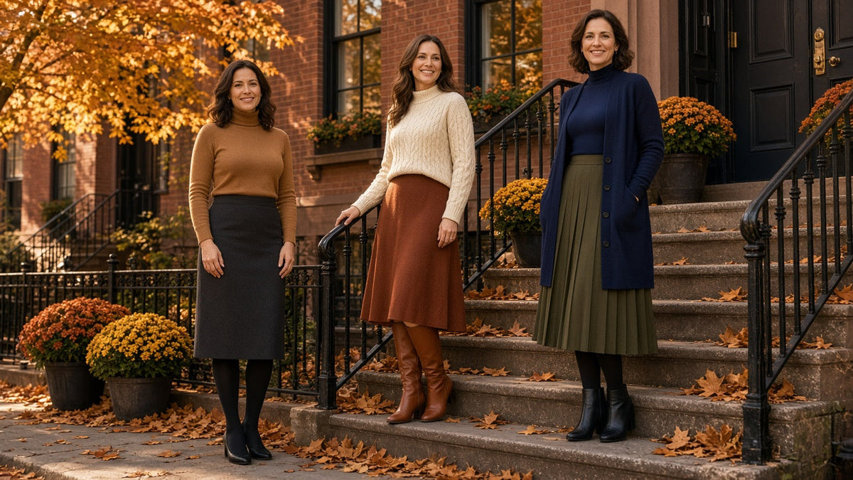 Three women on autumn brownstone steps in modest skirts of different lengths: a below-knee pencil skirt with tights and pumps, a mid-calf A-line skirt with tall boots, and a pleated midi skirt with tights and ankle boots